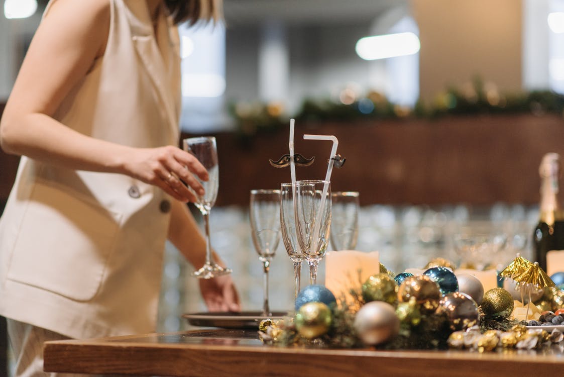 Person holding empty glass over a dining table