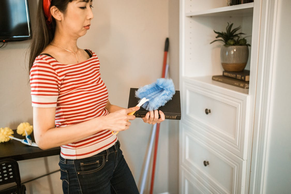 A woman dusting in her home