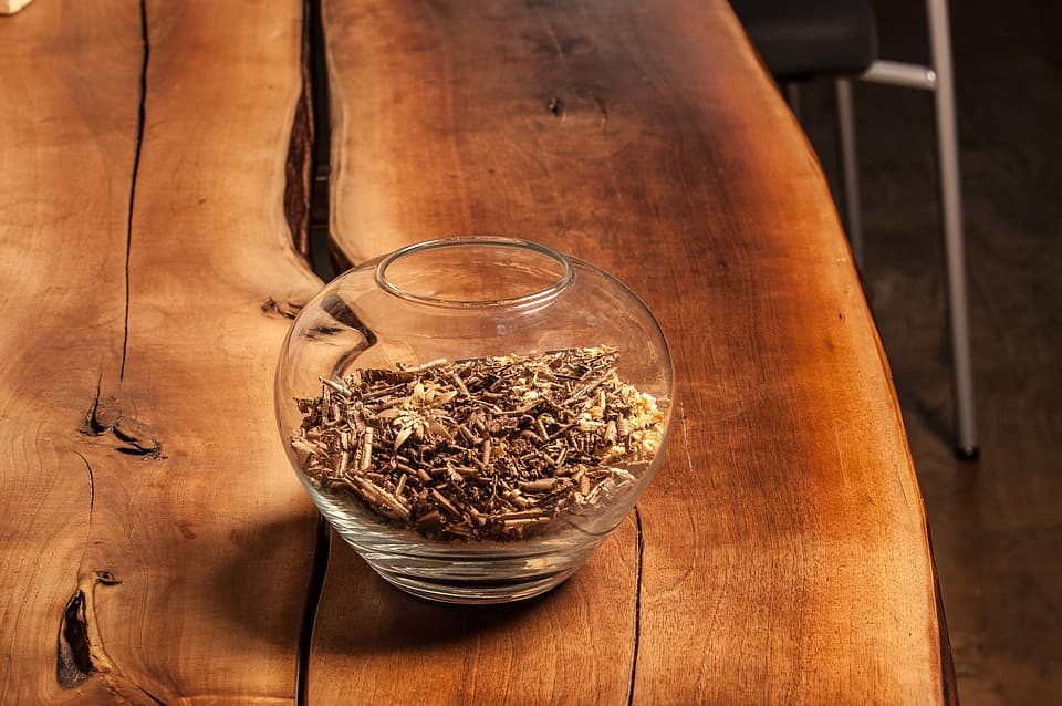 A glass pot on live-edge wooden table