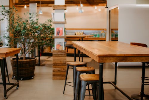 A wooden table with bar stools