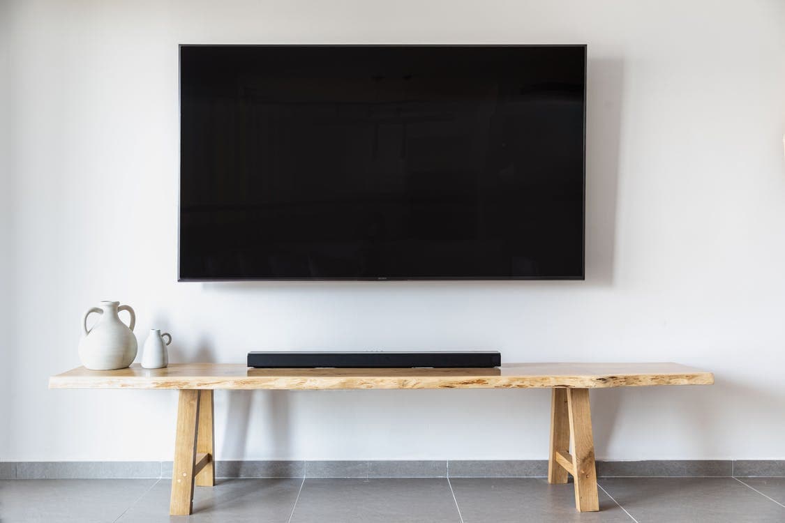 Wall-mounted TV over wooden table